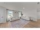 Bright living room with wood floors, featuring two white sofas, a patterned rug, and large windows for lots of light at 36 High View Ct, Fuquay Varina, NC 27526