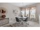 Bright dining area with a round table, gray chairs, elegant chandelier, and decorative shelving at 4007 Newell Ln, Raleigh, NC 27616
