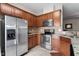A kitchen featuring stainless steel appliances, granite countertops, and warm brown cabinetry at 4007 Newell Ln, Raleigh, NC 27616
