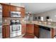 Modern kitchen with stainless steel appliances, wood cabinets, and granite countertops offers ample counter space at 4007 Newell Ln, Raleigh, NC 27616