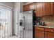 Kitchen featuring a stainless steel refrigerator, warm wood cabinetry, and tile backsplash at 4007 Newell Ln, Raleigh, NC 27616
