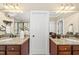 Well-lit bathroom with granite countertops, double sinks and mirrors at 401 Clingstone Ct, Cary, NC 27519