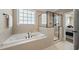 Luxurious bathroom with soaking tub, separate shower, and neutral tile at 401 Clingstone Ct, Cary, NC 27519