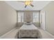 Cozy bedroom featuring a ceiling fan, two windows, and a comfortable bed with decorative pillows at 401 Clingstone Ct, Cary, NC 27519
