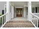 Inviting front entrance featuring a wood door, brick steps, and white columns at 401 Clingstone Ct, Cary, NC 27519