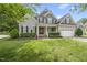 Charming two-story home with gray siding, black shutters, manicured lawn, and an attached two-car garage at 401 Clingstone Ct, Cary, NC 27519