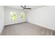 Bedroom features neutral carpeting, two windows and a modern ceiling fan at 407 1/2 Carolina Ave, Raleigh, NC 27606