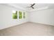 Sun-filled bedroom featuring a tray ceiling, ceiling fan, and large windows at 407 1/2 Carolina Ave, Raleigh, NC 27606