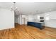 Spacious kitchen features hardwood floors, white cabinets, and a navy blue island with pendant lighting at 407 1/2 Carolina Ave, Raleigh, NC 27606