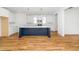 Bright kitchen features a large navy blue island with white countertops, white cabinets, and stainless steel appliances at 407 1/2 Carolina Ave, Raleigh, NC 27606