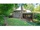 Back exterior view of the home featuring a screened porch and a spacious green yard at 4713 Little Falls Dr, Raleigh, NC 27609