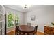 Well-lit formal dining room with dark wood table, hardwood floors, and a window view at 4713 Little Falls Dr, Raleigh, NC 27609