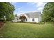 Large backyard with lush lawn, mature trees, landscaped garden beds, and a spacious deck for outdoor living at 4812 Cornoustie Ct, Holly Springs, NC 27540