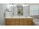 Bright bathroom featuring double sinks with a large mirror, and a separate glass-enclosed shower at 4812 Cornoustie Ct, Holly Springs, NC 27540