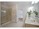 Spacious bathroom with double sinks, a glass-enclosed shower, and natural light from an open doorway at 4812 Cornoustie Ct, Holly Springs, NC 27540