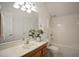 Bright bathroom with a single sink vanity, large mirror, and a combined tub and shower unit at 4812 Cornoustie Ct, Holly Springs, NC 27540