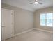 Neutral bedroom with ceiling fan, double door closet, carpet, and large window with blinds at 4812 Cornoustie Ct, Holly Springs, NC 27540