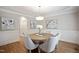 Formal dining room showcases a round wooden table, wainscoting detail, and elegant light fixture at 4812 Cornoustie Ct, Holly Springs, NC 27540