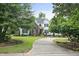 Picturesque home with a blend of brick and white siding, accented by lush greenery and a winding driveway at 4812 Cornoustie Ct, Holly Springs, NC 27540