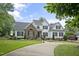 Elegant home showcasing a brick and white exterior, complemented by a dark roof and a neatly maintained lawn and driveway at 4812 Cornoustie Ct, Holly Springs, NC 27540