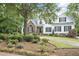 Charming two-story home featuring a blend of brick and white siding, complemented by a beautifully landscaped front yard at 4812 Cornoustie Ct, Holly Springs, NC 27540
