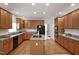 Large kitchen with a central island, wooden cabinetry, granite counters, and modern appliances at 4812 Cornoustie Ct, Holly Springs, NC 27540