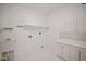 Functional laundry room features a sink, shelving, and ample counter space at 4812 Cornoustie Ct, Holly Springs, NC 27540