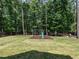 Spacious backyard with a playground area for , surrounded by tall trees at 497 Rockport Dr, Clayton, NC 27527