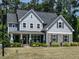 Charming two-story home with stone accents, a covered porch, and manicured lawn at 497 Rockport Dr, Clayton, NC 27527