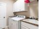 Convenient laundry room with modern washer and dryer, sink, white cabinets, and granite countertops at 497 Rockport Dr, Clayton, NC 27527