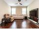 Living room boasts a ceiling fan, windows, wood floors, TV and furniture at 497 Rockport Dr, Clayton, NC 27527