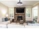 Inviting living room with stone fireplace, large windows, and comfortable seating arrangement at 497 Rockport Dr, Clayton, NC 27527