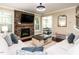 Bright living room with stone fireplace, large windows, and comfortable seating arrangement at 497 Rockport Dr, Clayton, NC 27527