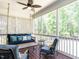Cozy screened-in porch with a hanging swing sofa, ceiling fan, and wooded view at 497 Rockport Dr, Clayton, NC 27527
