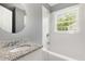 Bright bathroom featuring granite-look vanity, round mirror, and tub-shower with window at 518 Avon Ave, Burlington, NC 27215