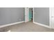 Bedroom with neutral carpet, gray walls, and trim, features a doorway to other rooms at 518 Avon Ave, Burlington, NC 27215
