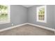 Bright bedroom featuring neutral carpet, gray walls, and natural light from the double-hung windows at 518 Avon Ave, Burlington, NC 27215