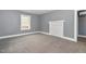 A bright bedroom with gray walls, white trim, gray carpet, and decorative mantel at 518 Avon Ave, Burlington, NC 27215