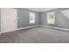 Bright bedroom featuring gray walls, gray carpet, and white trim with two windows at 518 Avon Ave, Burlington, NC 27215