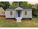 Charming single-story home featuring gray siding, a blue front door and a well-maintained lawn at 518 Avon Ave, Burlington, NC 27215