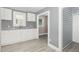 An airy kitchen with white cabinets, gray countertops, and gray vinyl flooring at 518 Avon Ave, Burlington, NC 27215