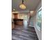 Open kitchen features wood cabinets, backsplash, and new flooring next to the stairwell at 523 Berry Chase Way, Cary, NC 27519