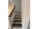 A carpeted staircase with a wooden handrail, providing safe and stylish access to upper levels at 523 Berry Chase Way, Cary, NC 27519