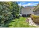 Large landscaped backyard with a lush lawn, decorative borders, and various trees at 534 Elm Ave, Wake Forest, NC 27587