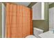 This cozy bathroom features a shower with an orange curtain and a white medicine cabinet at 534 Elm Ave, Wake Forest, NC 27587
