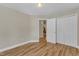 Well-lit bedroom featuring hardwood floors, neutral walls, and closet with bi-fold doors at 534 Elm Ave, Wake Forest, NC 27587