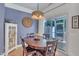 Well-lit dining area featuring a wooden table, modern lighting, and sliding glass doors for outdoor access at 534 Elm Ave, Wake Forest, NC 27587