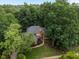 Aerial view of a stunning brick home nestled among mature trees, offering privacy at 541 The Preserve Trail Trl, Chapel Hill, NC 27517