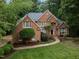 Elegant brick home featuring a well-maintained lawn, mature trees and inviting curb appeal at 541 The Preserve Trail Trl, Chapel Hill, NC 27517