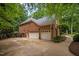 Spacious three-car garage of a brick home with ample parking and storage, enhanced by landscaping at 541 The Preserve Trail Trl, Chapel Hill, NC 27517
